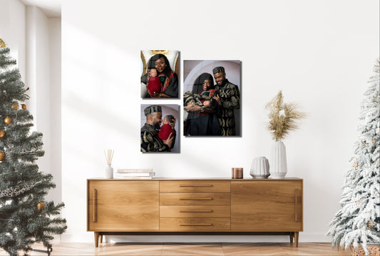 Three framed portraits on a wall above a wooden sideboard with Christmas trees on either side.